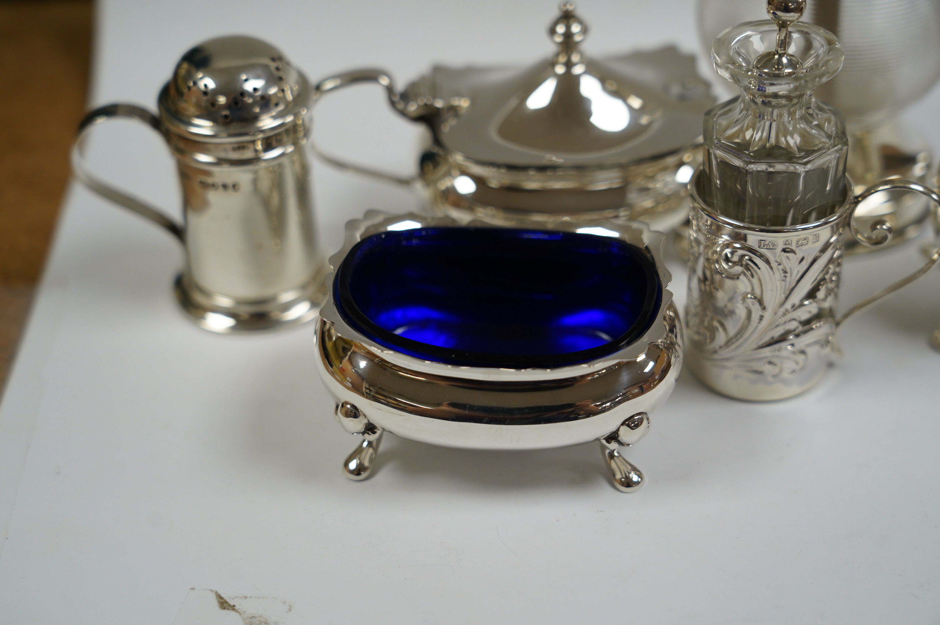 Six assorted silver condiments including a mounted ribbed glass pepper grinder and an Edwardian mounted glass cayenne pepper condiment, Condition - fair to good